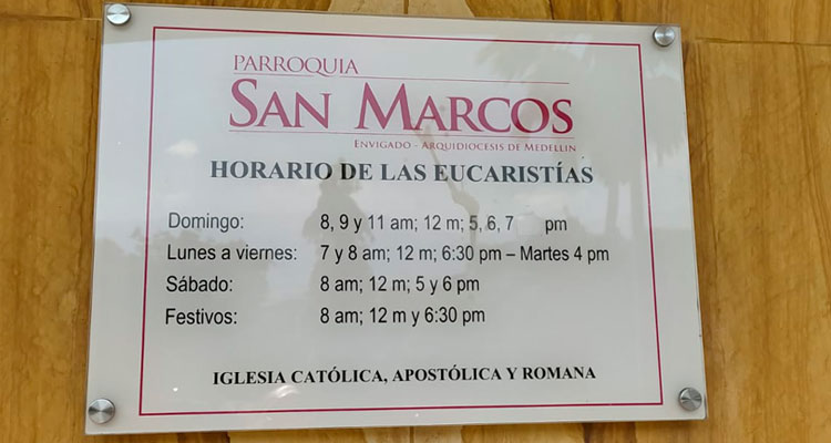 Letrero con los horarios de las misas en la parroquia san marcos